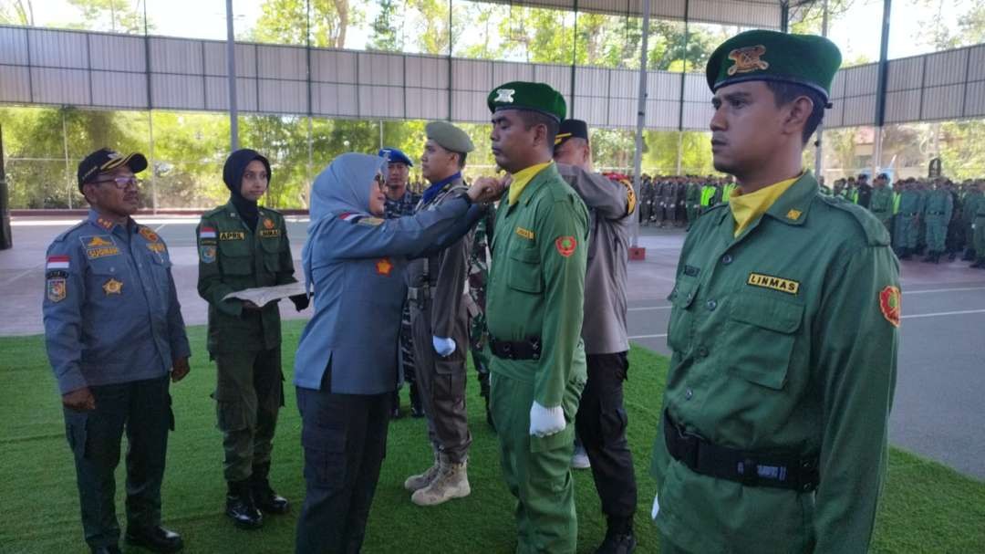 Bupati Banyuwangi menyematkan tanda kepada perwakilan anggota Linmas (foto: Muh Hujaini/Ngopibareng.id)