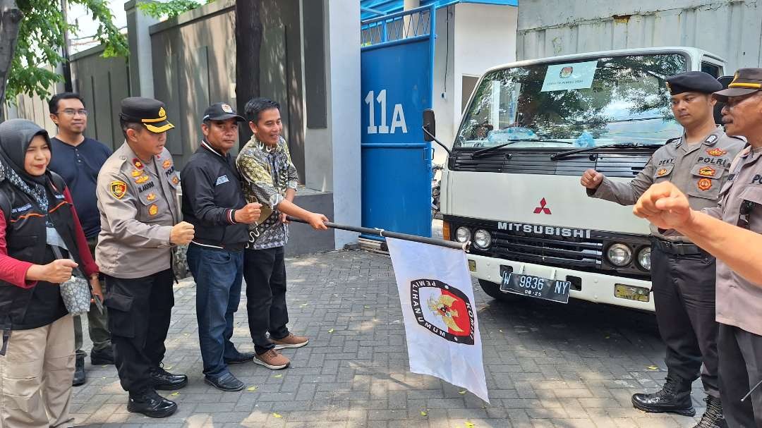 Ketua KPU Kota Surabaya, Nur Syamsi saat mengibarkan bendera KPU pada prosesi pemberangkatan logistik Pemilu 2024, Jumat 2 Februari 2024, bertempat di Gudang Logistik Pemilu Margomulyo. (Foto: Julianus Palermo/Ngopibareng.id)