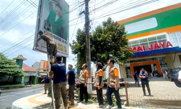 Bawaslu Bondowoso mencopoti alat peraga kampanye (APK). Kondisi harus steril APK H-1 coblosan Pemilu, Selasa, 13 Februari 2024. (Foto: Guido Saphan/Ngopibareng.id)