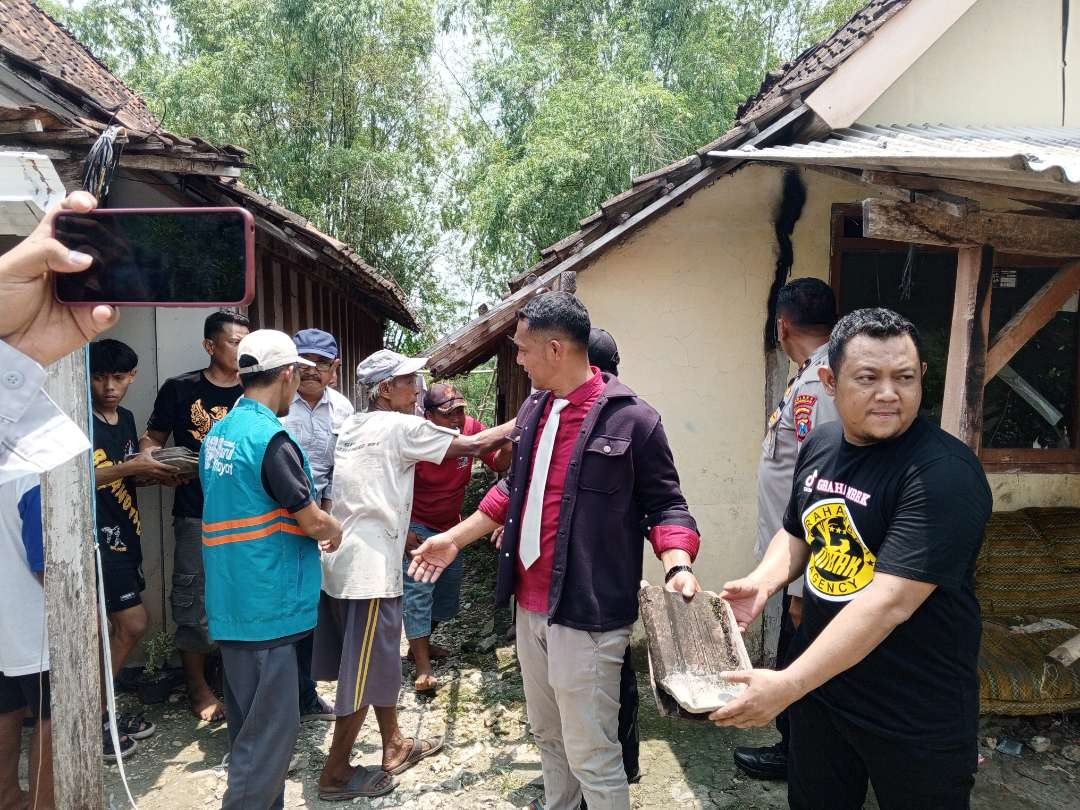 Simbolis penurunan genting baksos bedah rumah PWI Lamongan bersama Polres Lamongan dan donatur di Desa Keyongan, Babat, Lamongan (Foto: Imron Rosidi/Ngopibareng.id)