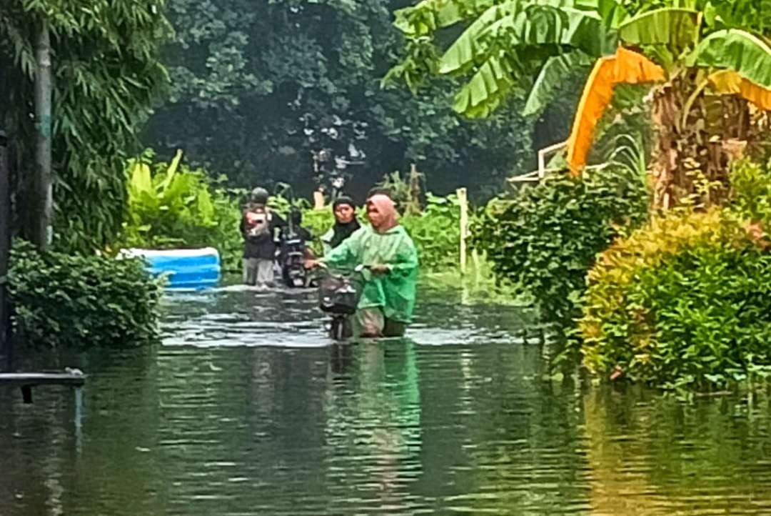 Warga Trosobo, Sidoarjo, beraktivitas di tengah banjir. (Foto: Aini Arifin/Ngopibareng.id)