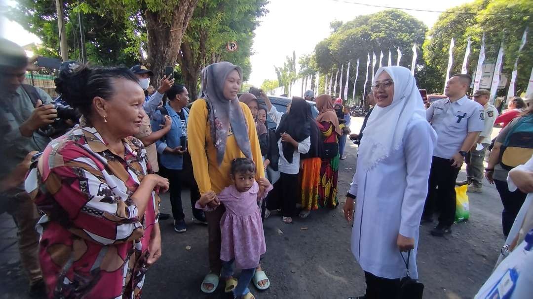 Bupati Banyuwangi Ipuk Fiestiandani berbincang dengan warga yang sedang antre di pasar murah (Foto: Muh Hujaini/Ngopibareng.id)