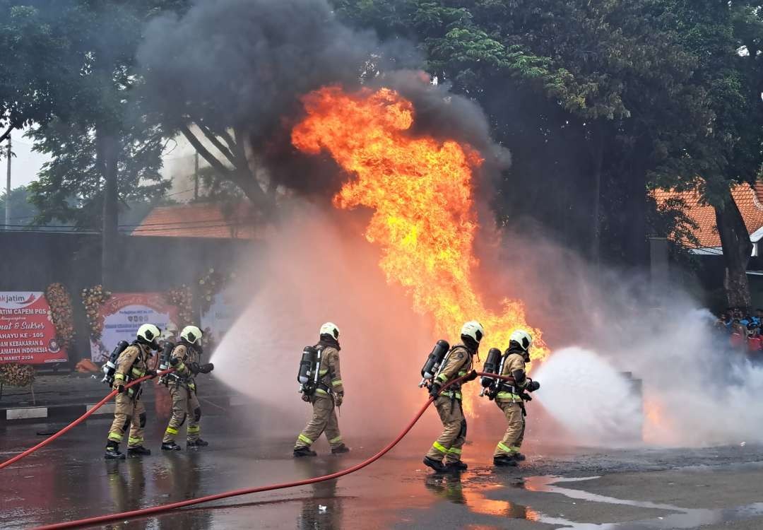 Atraksi Damkar dalam perayaan Hari Jadi ke 105. Petugas Damkar saat melakukan aksi pemadam api. (Foto: Pita Sari/Ngopibareng.id)