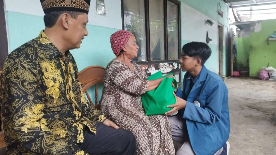 Perwakilan mahasiswa menyerahkan sembako ke rumah salah satu warga dengan disaksikan Kepala Desa Macan Putih, M. Farid. (Foto: Muh Hujaini/Ngopibareng.id)