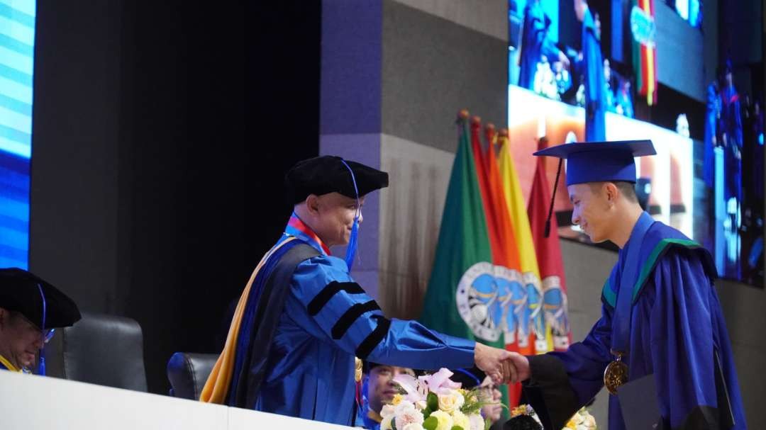 Rektor Universitas Kristen Petra Prof. Djwantoro Hardjito, saat mengucapkan selamat kepada salah satu wisudawan periode ke-85. (Foto: Humas UK Petra)