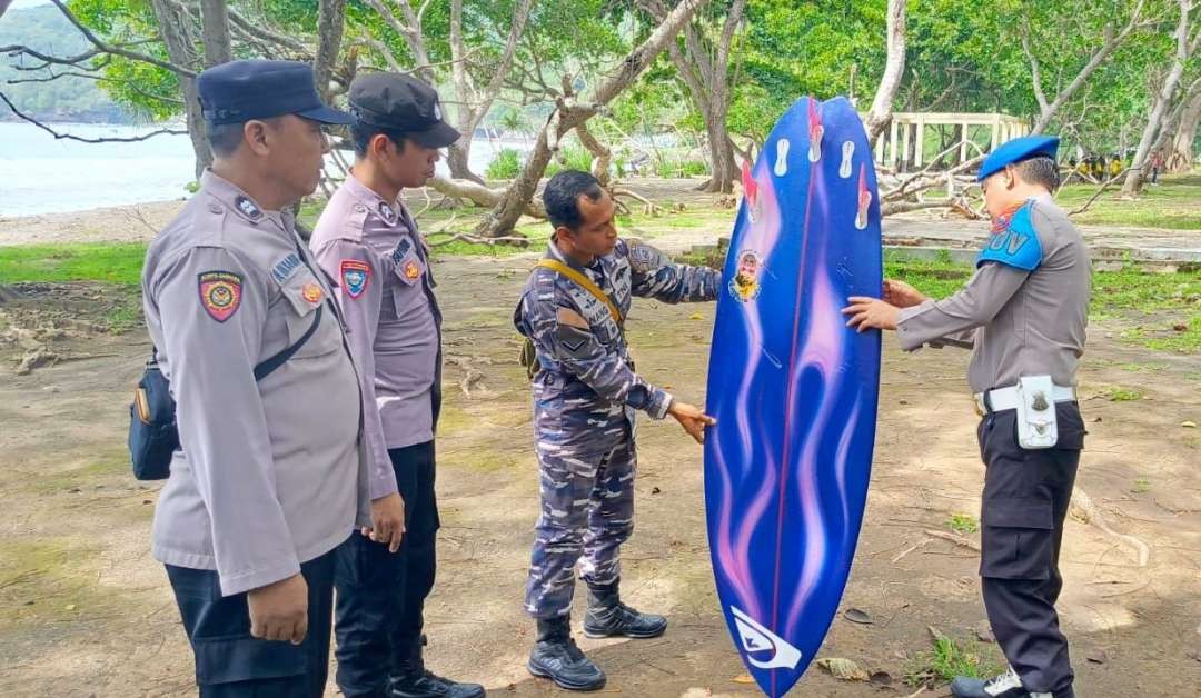 Petugas menunjukkan papan selancar milik korban (foto:istimewa)