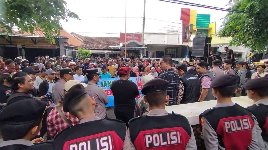 Dua komisioner Bawaslu Banyuwangi menemui massa pendukung caleg demo, dengan pengawalan ketat aparat kepolisian. (Foto: Muh Hujaini/Ngopibareng.id)