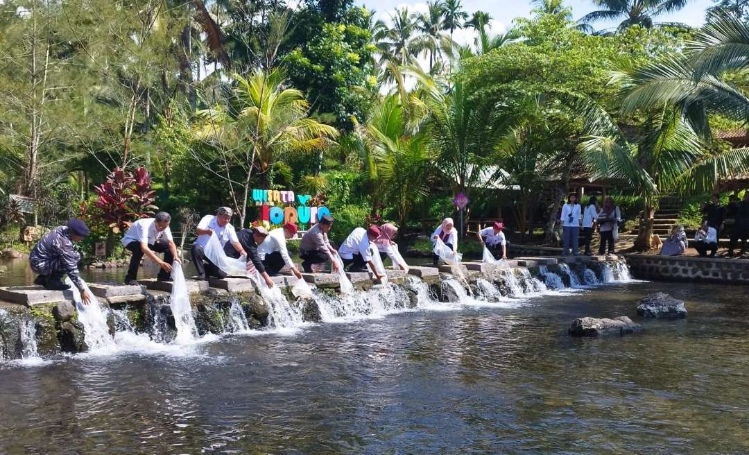 Bupati Banyuwangi Ipuk Fiestiandani bersama Kepala SKP dan Pejabat Utama Pemkab Banyuwangi melepas benih ikan di wisata Sungai Jopuro. (Foto: Muh. Hujaini/Ngopibareng.id)