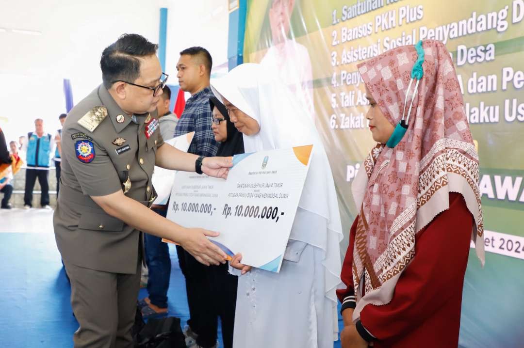 Pj Gubernur Jawa Timur, Adhy Karyono, saat memberikan santunan kematian bagi keluarga petugas pemilu yang gugur di Jember. (Foto: Dokumentasi Pemprov Jatim)