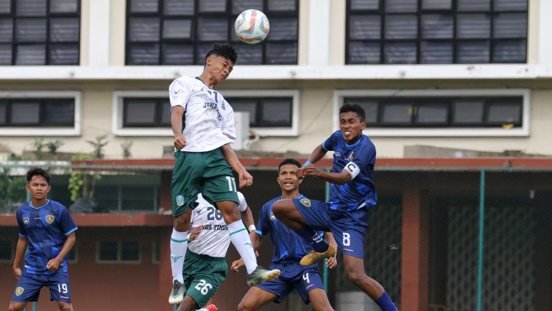 Pemain Jatim, Aqsa Rabbani (putih) menyundul bola saat melawan Maluku dalam BK PON di Lapangan Thor, Surabaya, Kamis 7 Maret 2024. (Foto: Fariz Yarbo/Ngopibareng.id)