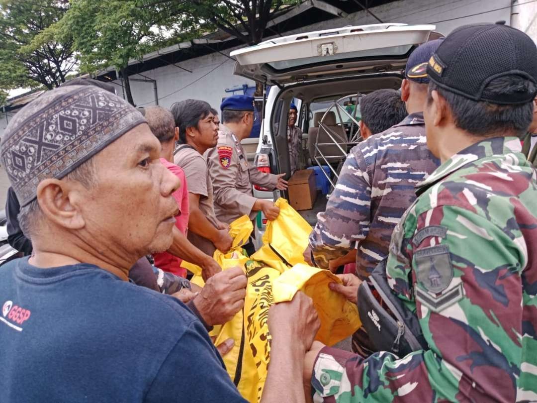 Petugas mengevakuasi jenazah Hisbulloh Huda, nelayan yang tenggelam. (Foto: Satpolairud Probolinggo).