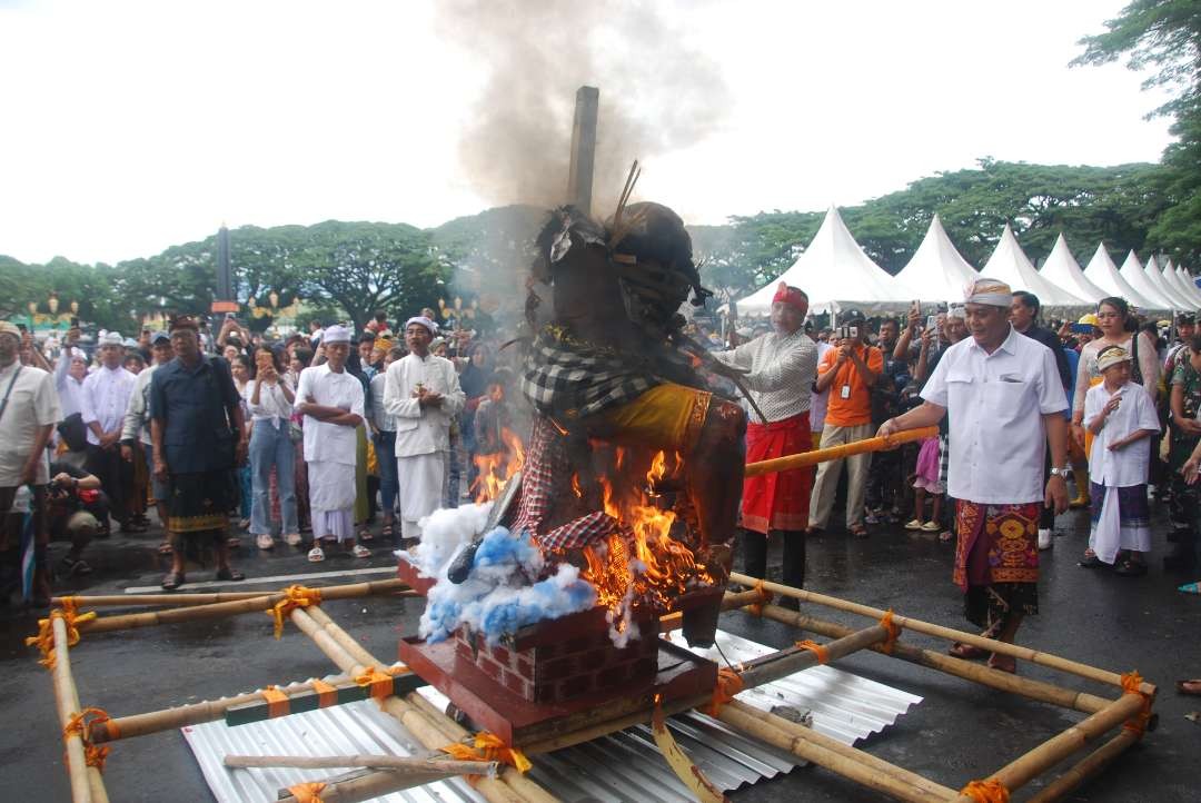 Pj Wali Kota Malang Wahyu Hidayat (kiri) dan Ketua DPRD Kota Malang I Made Irawan (kanan) secara simbolis membakar salah satu ogoh-ogoh usai diarak di Alun-alun Tugu Malang pada Minggu, 10 Maret 2024. (Foto: Moh Badar Risqullah/Ngopibareng.id)