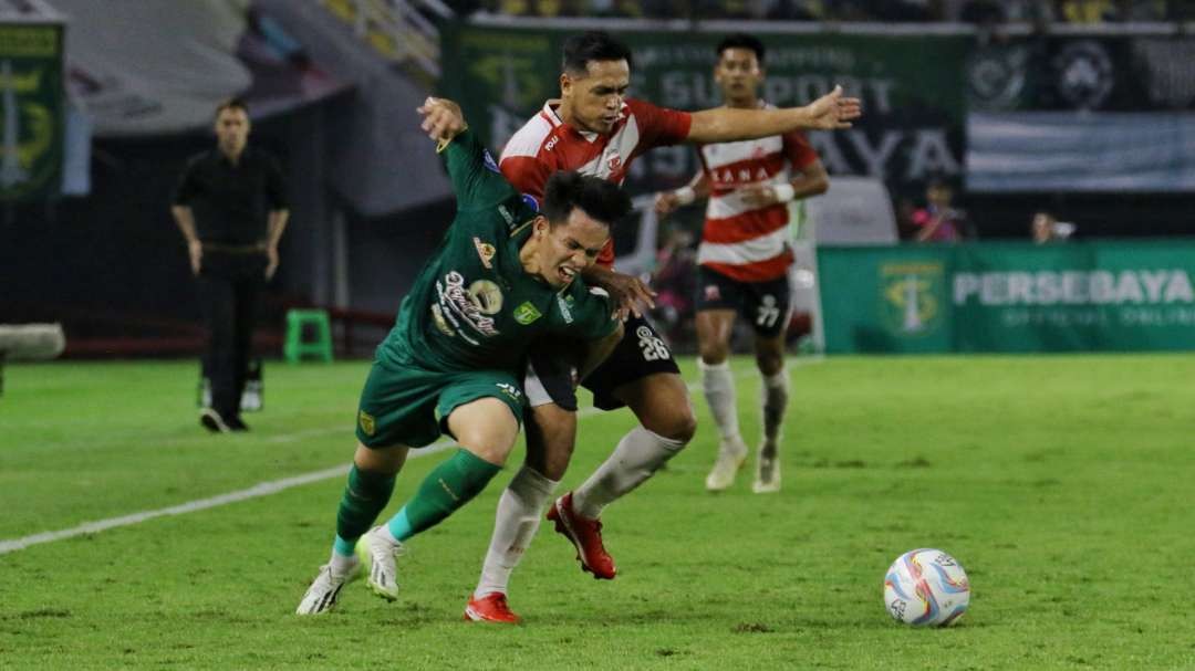 Pemain Persebaya, Wildan Ramadhan (hijau) mendapat pengawalan ketat pemain Madura United Novan Sasongko. (Foto: Fariz Yarbo/Ngopibareng.id)