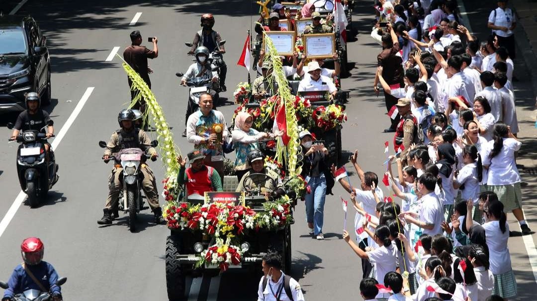 Dengan mengendarai mobil jeep, Walikota Surabaya, Eri Cahyadi didampingi Ketua TP PKK Surabaya, Rini Indriyani, memimpin arak-arakan Adipura Kencana bersama sejumlah penghargaan lain di bidang lingkungan hidup. (Foto: Pemkot Surabaya)