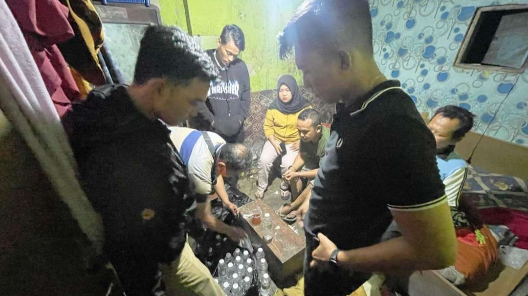 Petugas kepolisian mengamankan minuman keras jenis arak dari rumah warga Kalibaru Manis, Banyuwangi, Jawa Timur. (Foto: Istimewa)