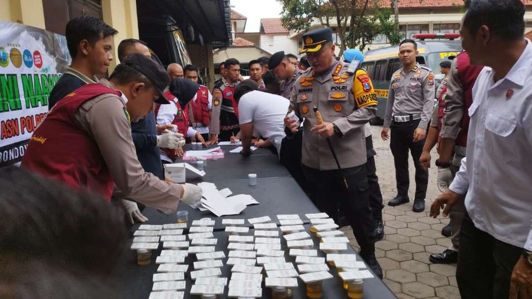 Kapolresta Banyuwangi Kombespol Nanang Haryono mengambil wadah untuk sampel urin (Foto: Muh Hujaini/Ngopibareng.id)