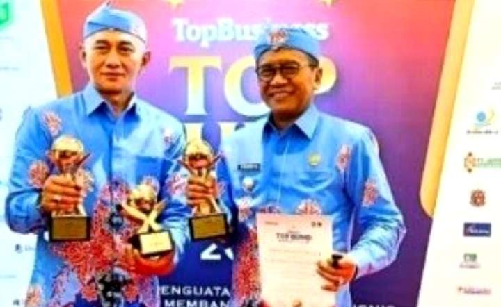 Direktur PDAM Bondowoso April Ariestha Bhirawa (kiri) dengan Pj. Bupati Bondowoso Bambabg Soekwanto dengan tiga trofi diraih di ajang TOP BUMD Awards 2024.(Foto: Dok. PDAM Bondowoso)