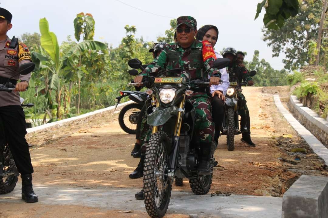 Dandim 0721/Blora Letkol Czi Yuli Hartanto dan Wakil Bupati Blora Tri Yuli Setyowati berboncengan melihat hasil pembangunan TMMD. (Humas Pemkab Blora)