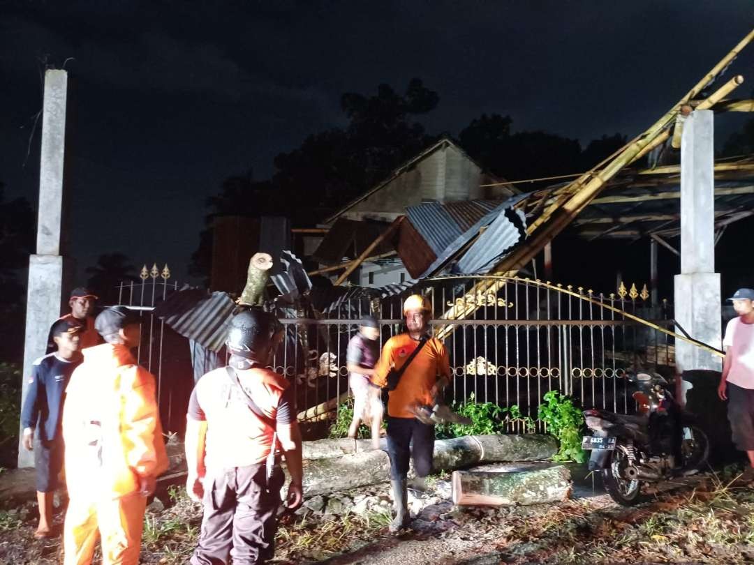 TRC BPBD Jember membersihkan material pohon tumbang yang menimpa rumah warga. (Foto: Dok. TRC BPBD Jember)