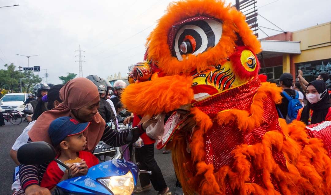 Atraksi barongsai di Sidoarjo sambil bagikan takjil berbuka puasa (foto :Aini/Ngopibareng.id)