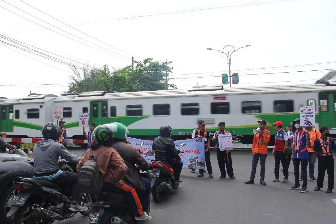 Petugas KAI Daop 8 Surabaya saat mengimbau masyarakat sadar berlalu lintas pada wilayah perlintasan sebidang. (Foto: Humas KAI Daop 8 Surabaya)