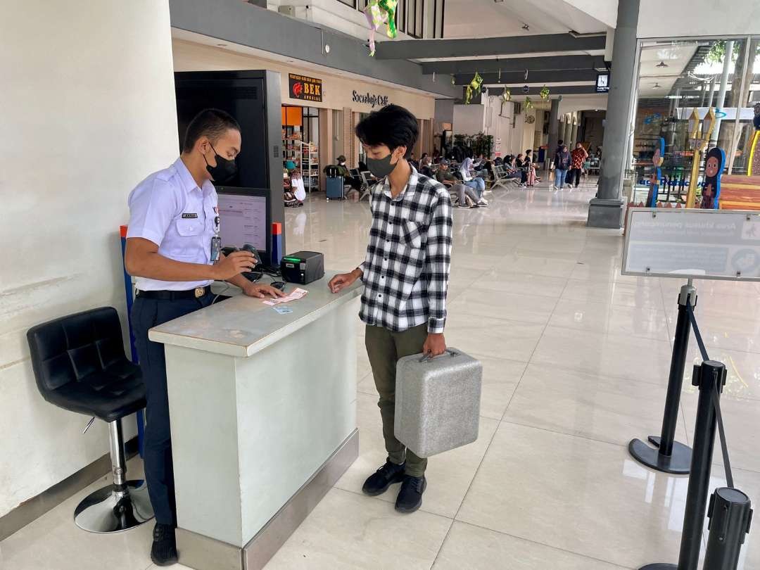 Salah satu pelanggan yang akan boarding di Stasiun Surabaya Gubeng, sambil membawa bagasi. (Foto: Humas KAI Daop 8)