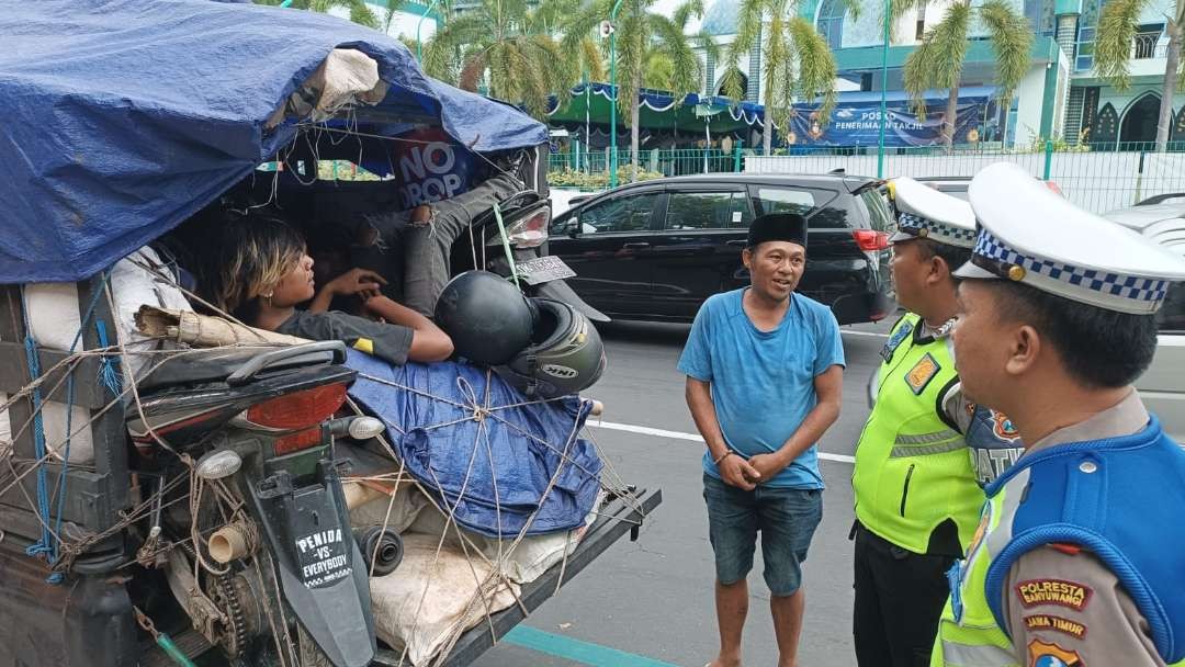 Polisi menghentikan kendaraan bak terbuka yang digunakan mengangkut pemudik. (Foto: Istimewa)