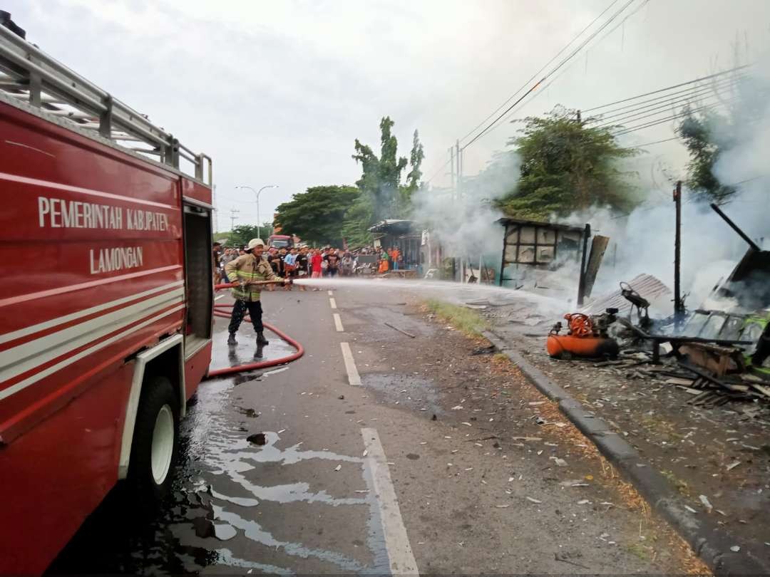 Petugas Damkar Korwil Lamongan sedang memadamkan api di lokasi kebakaran. (Foto: Istimewa)