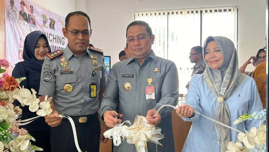 Kepala Kantor Imigrasi Bandung Agung Pramono mendampingi  Pj Bupati Sumedang, Yudia Ramli, memotong pita pada pembukaan stan layanan Keimigrasian di MPP Kabupaten Sumedang. (Foto: Kemenkumham)