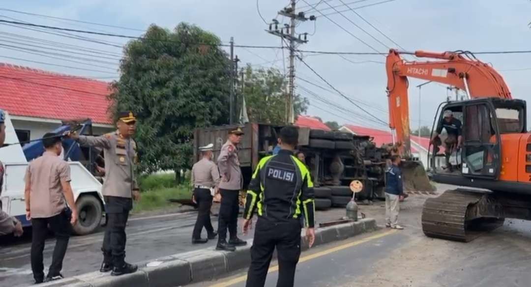 Polisi gunakan alat berat untuk evakuasi truk.(Foto: Deni Lukmantara/Ngopibareng.id)