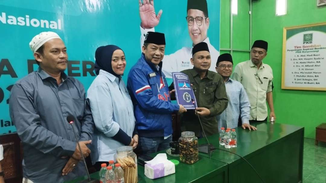 Ketua DPC Partai Demokrat Banyuwangi Michael Edy Hariyanto menyerahkan persyaratan kepada ketua DPC PKB Banyuwangi Gus Malik (foto: Muh Hujaini/Ngopibareng.id)