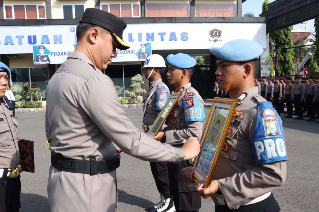 Kapolres Lamongan AKBP Bobby Chondroputra mencuret foto kedua anggota yang disanksi PDTH dengan garis silang (Foto: Istimewa)