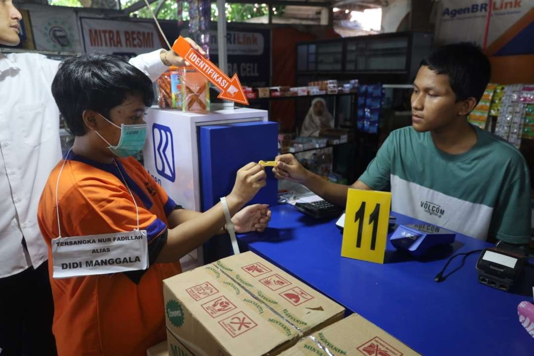 Tersangka saat memeragakan membeli racun tikus. (Foto: Imron Rosidi/Ngopibareng.id)