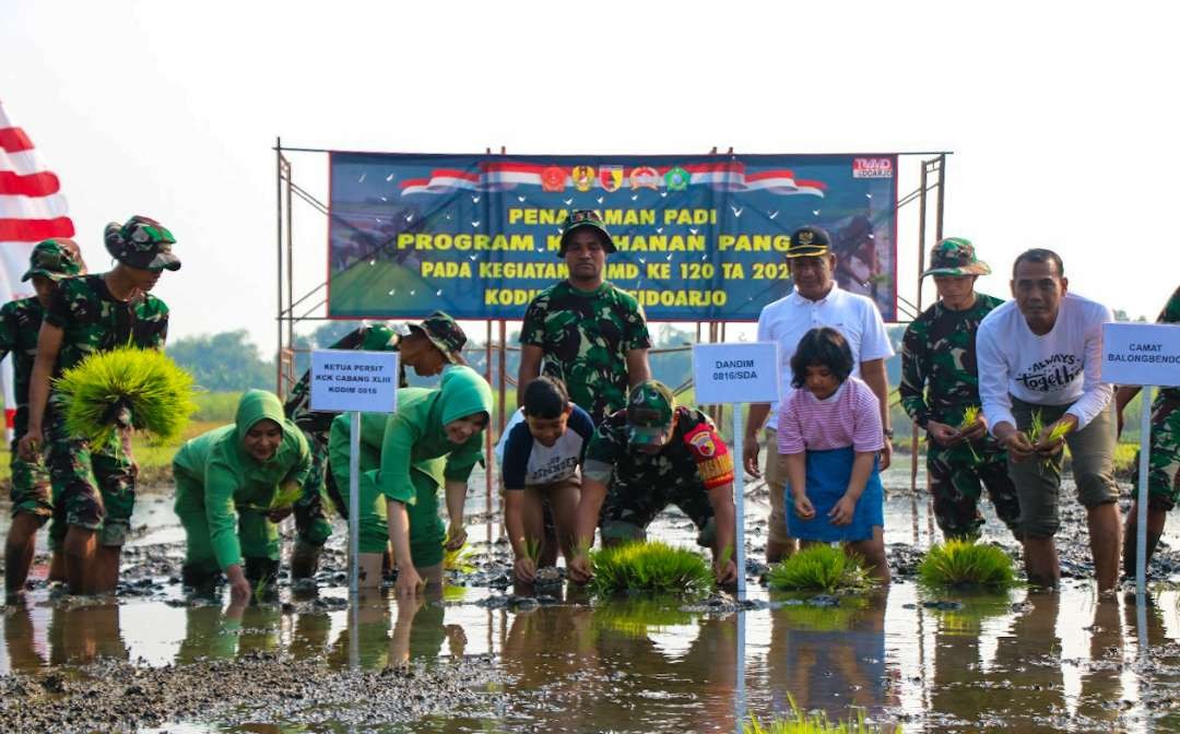 Satgas TMMD saat tanam padi di Desa Penambangan. (Foto: Aini Arifin/Ngopibareng.id)