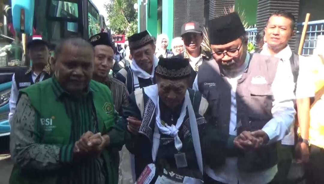 CJH asal Ponorogo, Hardjo Mislan dibantu petugas saat tiba di Asrama Haji Sukolilo, Surabaya, Rabu 15 Mei 2024. (Foto: Fariz Yarbo/Ngopibareng.id)