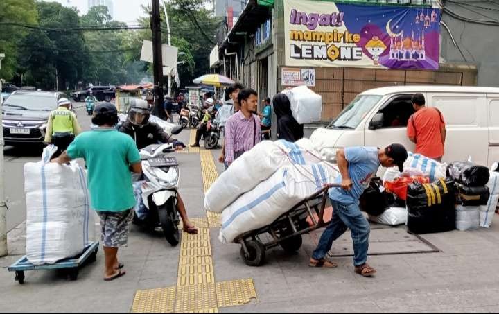 Kuli angkat barang di Pasar Tanah Abang tetap semangat meskipin menghadapi tantangan  penjualan online (Foto: Asmanu Sudarso/ngopibareng.id)