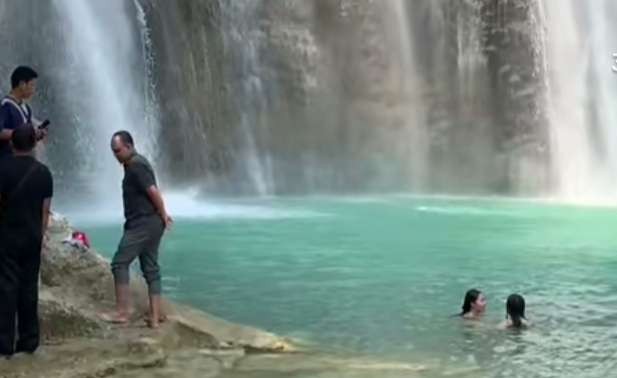 Tangkapan layar video dua wisatawan mandi dan berenang di bawah Air Terjun Putri Nglirip Tuban. (Foto: Istimewa)