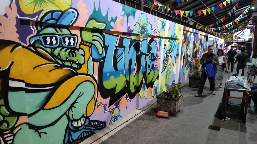 Pengunjung saat menyaksikan pameran mural East Side Gallery Meets Surabaya di Wisma Jerman, Surabaya, Sabtu 18 Mei 2024. (Foto: Fariz Yarbo/Ngopibareng.id)