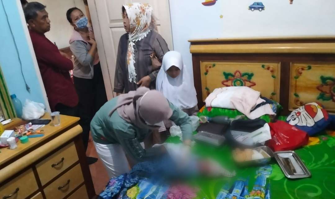 Bayi yang ditemukan warga sedang mendapatkan perawatan oleh bidan desa (Foto:istimewa)