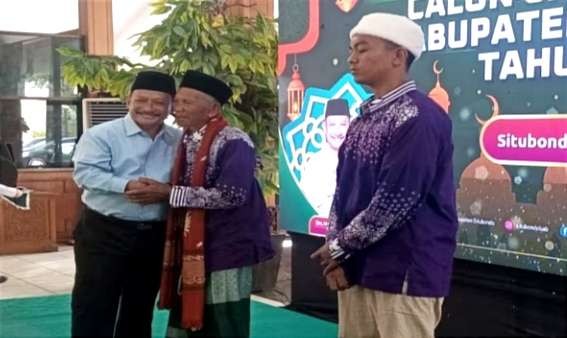 Bupati Karna Suswandi memberikan selamat kepada JCH tertua dan termuda Situbondo pada ibadah haji 2024.(Foto: Humas Kemenag Situbondo)