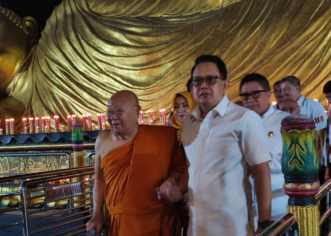 Pj Gubernur Jawa Timur, Adhy Karyono didampingi Bupati Mojokerto, Ikfina Fahmawati disambut pendiri Maha Vihara Majapahit Bhante Viriyanadi Mahathera. (Foto: Deni Lukmantara/Ngopibareng.id)