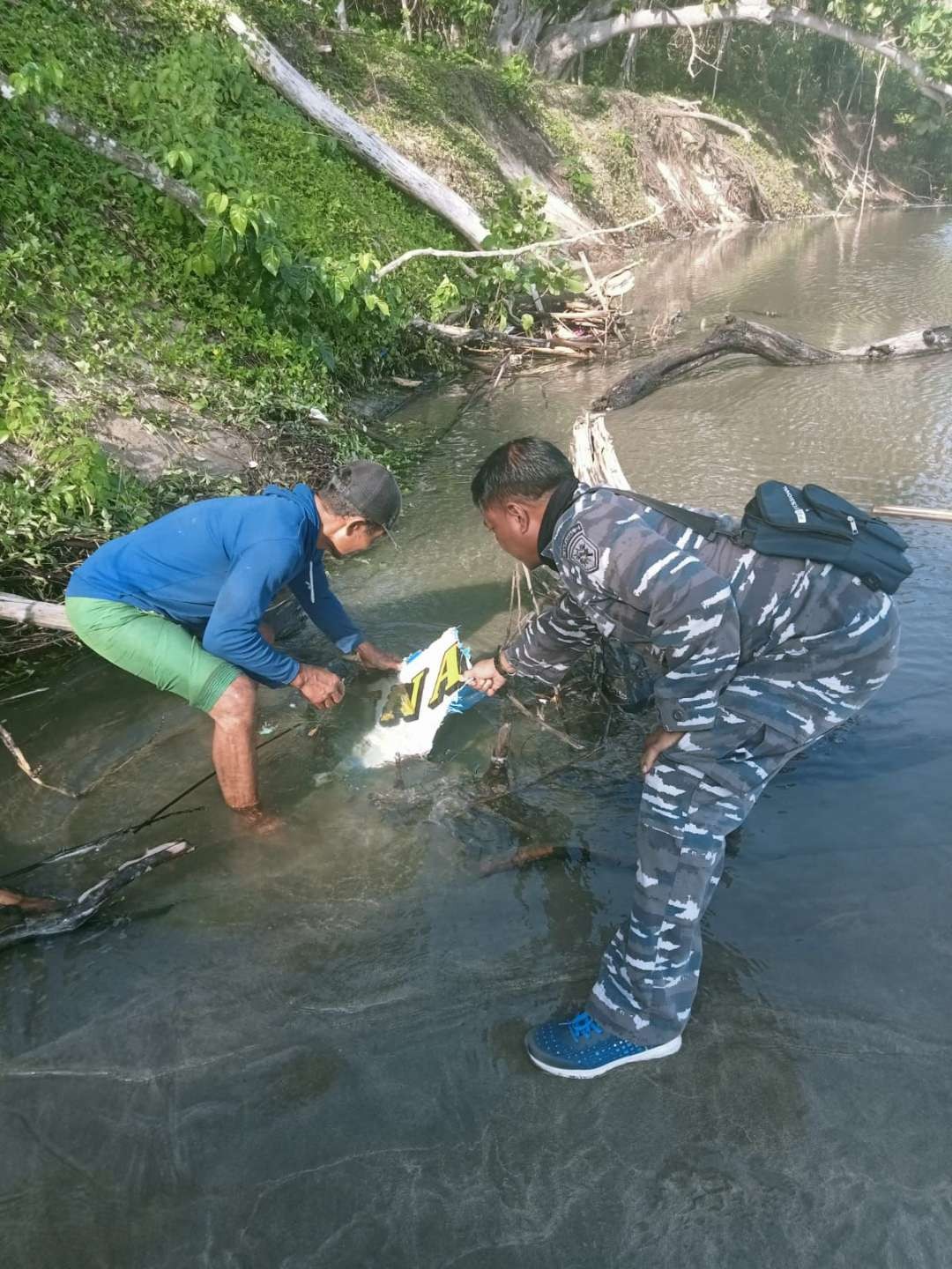 Petugas mengambil serpihan perahu di sekitar pantai triangulasi (foto: istimewa)