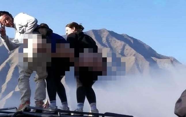 Tiga wisatawan mancanegara (wisman) berfoto bersama dengan menunjukkan pantat di kawasan Gunung Bromo. (Foto: Grup WA)