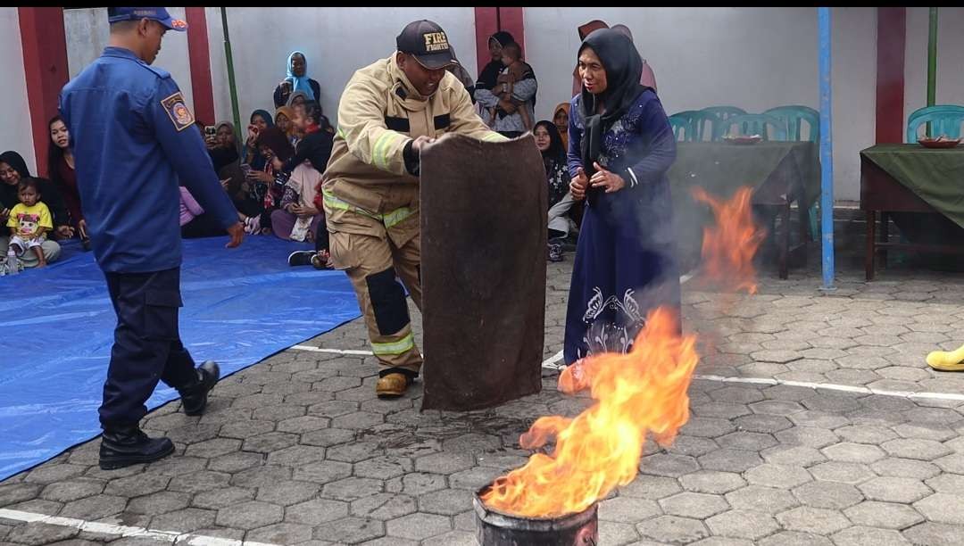 Seorang ibu rumah tangga serius memperhatikan petunjuk dari petugas pemadam kebakaran. (Foto: Humas Pemkab Banyuwangi)