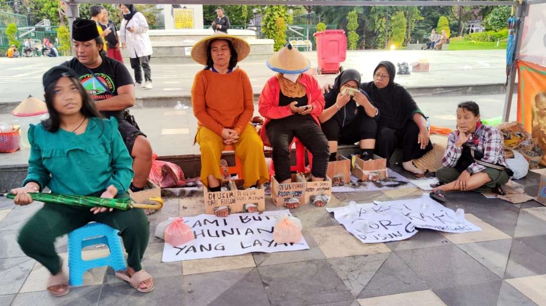 Sejumlah warag terdampak penggusuran Rusunawa Gunungsari melakukan aksi cor kaki di depan Gedung Negara Grahadi, Surabaya, Kamis 6 Juni 2024. (Foto: Fariz Yarbo/Ngopibareng.id)