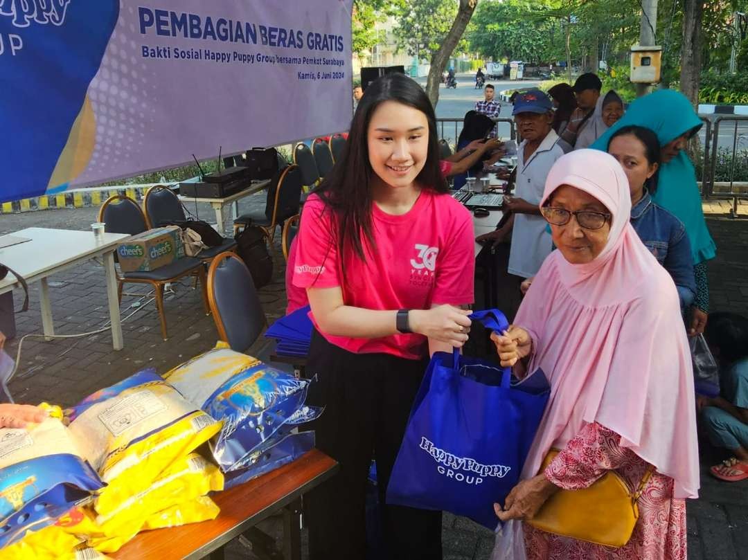 Steffiani Setyadji membagikan beras kepada masyarakat sekitar lokasi outlet Happy Puppy di Jalan Mayjend Sungkono. (Foto: Istimewa)