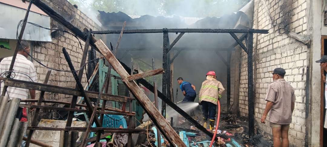 Petugas Damkar Korwil Lamongan sedang memadamkan api rumah korban (Foto: Istimewa)