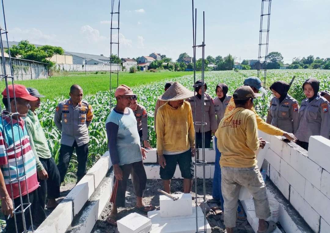 AKBP Ihram Kustarto bersama Polwan Polres Mojokerto membantu pembuatan tandon air diarea persawahan desa Jabon.(Foto Deni Lukmantara/Ngopibareng.id)