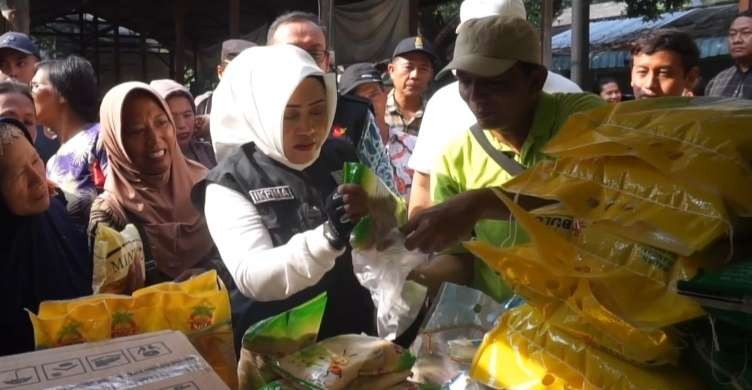 Bupati Ikfina saat layani pembeli di pasar murah.(Foto: Deni Lukmantara/Ngopibareng)