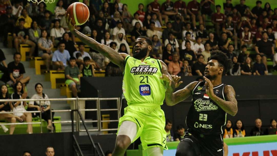 Pemain Pacific Caesar, Kelvij Blevins (hijau) melakukan lay up saat melawan Rans Simba Bogor di GOR Pacific, Surabaya, Minggu 16 Juni 2024 malam. (Foto: Fariz Yarbo/Ngopibareng.id)